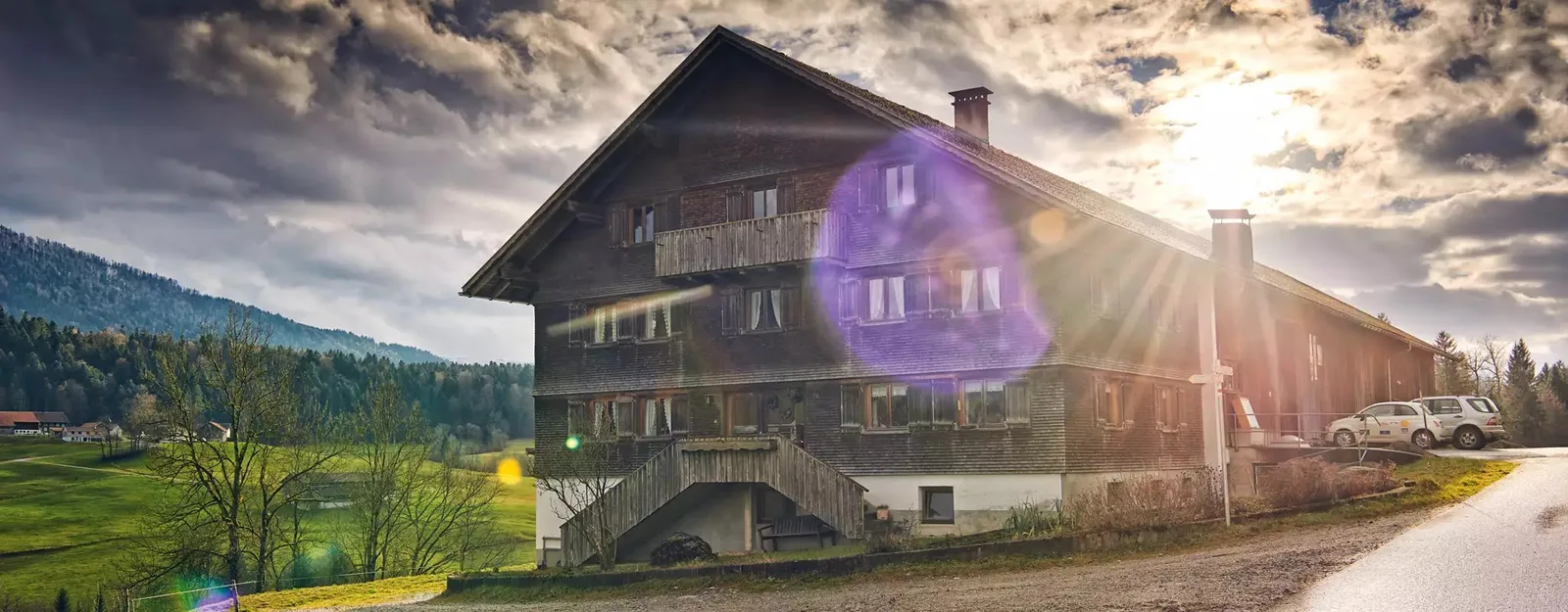 Der Felsenhof, ein Bregenzerwälder Schindelhaus, im Gegenlicht der tiefstehenden Sonne